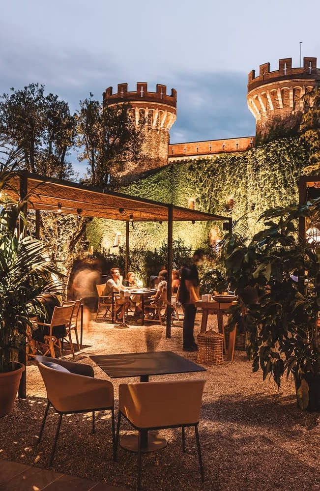 A candlelit restaurant terrace below castle towers